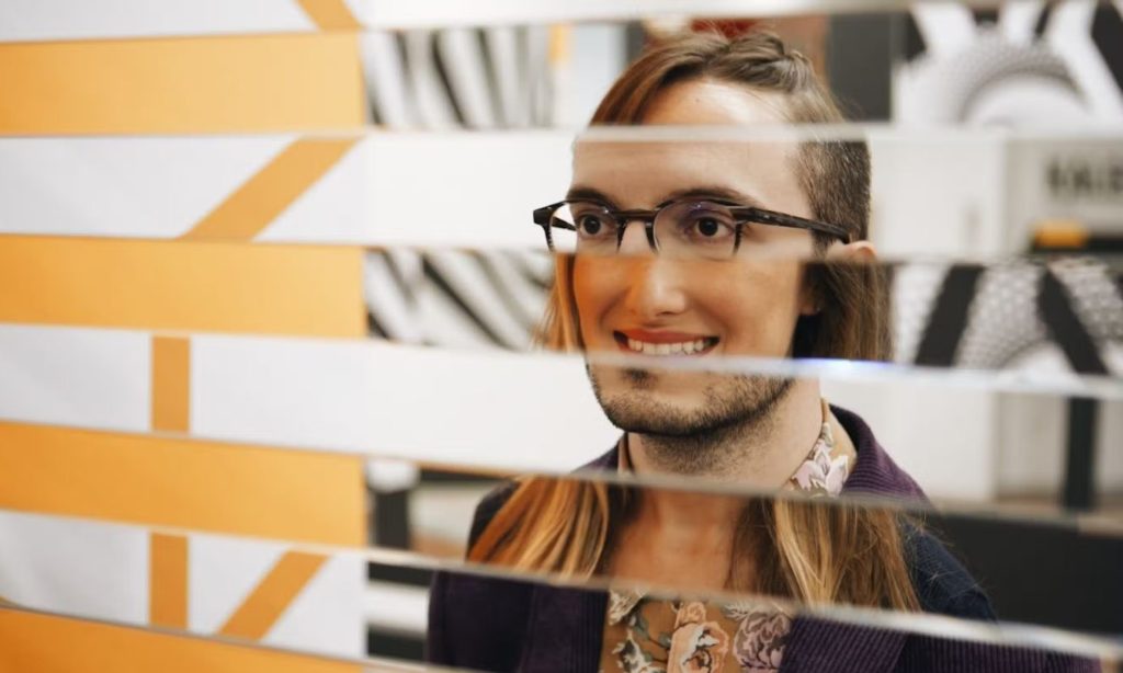 Visitors posing in an optical illusion setup at the Museo delle Illusioni in Rome, creating the effect of being pulled sideways.